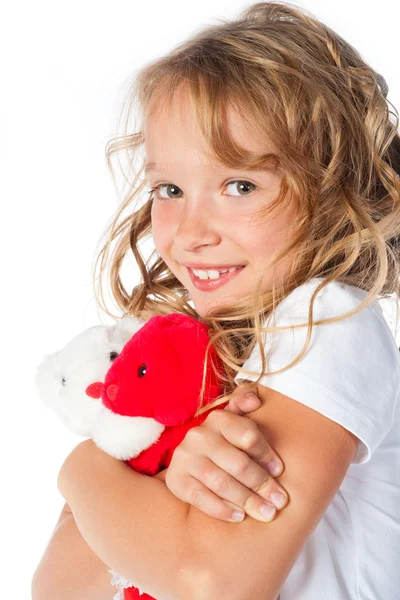 Schöne junge Mädchen umarmt ein Spielzeug — Stockfoto