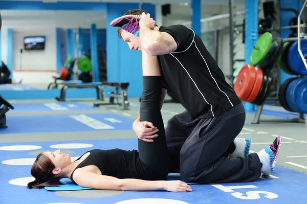 Been uitrekkende met personal trainer — Stockfoto