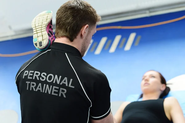 Personal trainer helping with stretches — Stock Photo, Image