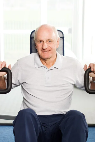 Hombre mayor haciendo ejercicio en el gimnasio — Foto de Stock