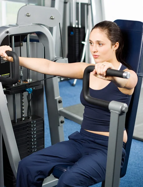 Giovane donna che si esercita in palestra — Foto Stock