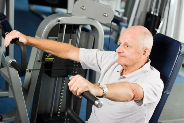 Hombre mayor haciendo ejercicio en el gimnasio — Foto de Stock