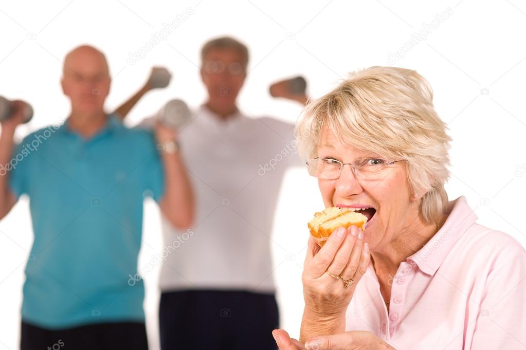 Mature lady eating cake at the gym