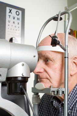 Older man having eye examination clipart