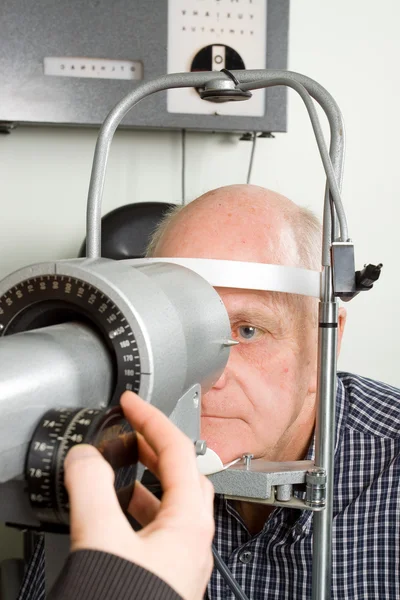 Hombre mayor examinándose los ojos — Foto de Stock