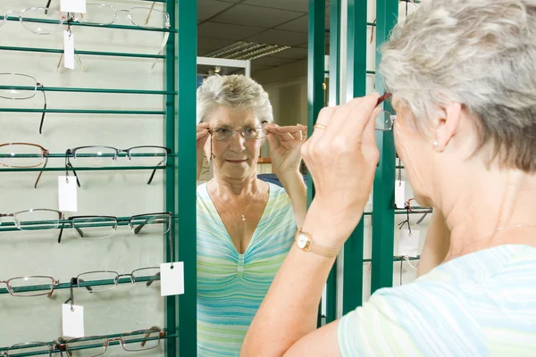 La elección de gafas en el óptico — Foto de Stock