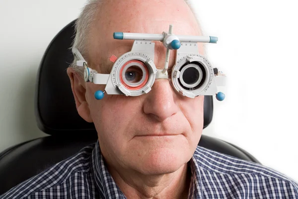 Uomo più vecchio con esame oculistico Foto Stock