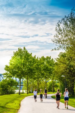 birkaç kadın çalışan ve nehrin yanında güzel yeşil park Bisiklete binme