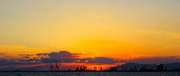 Handel haven bij zonsondergang met de bergen op de achtergrond — Stockfoto