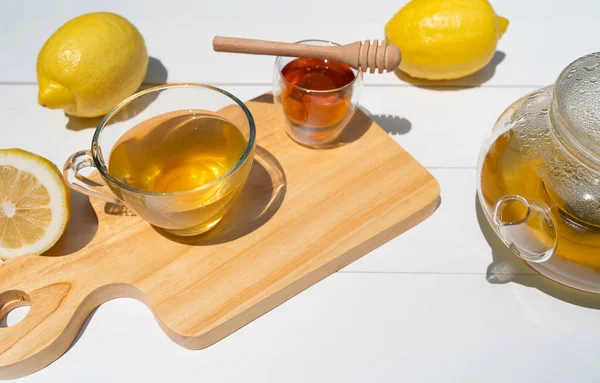 hot afternoon tea with honey and lemon served on table in cafe