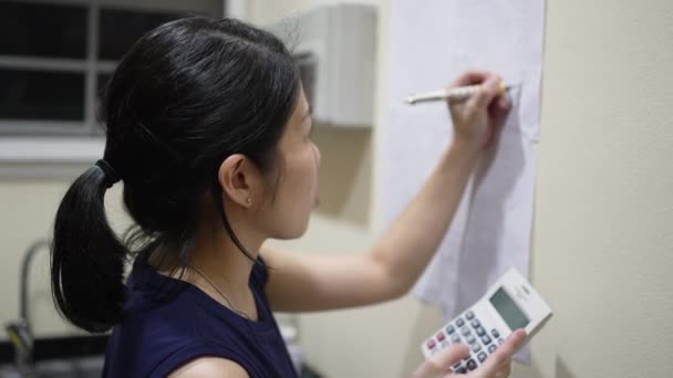 Asiático Adulto Mujer Escritura Calculado Ingreso Gasto Papel Pared — Vídeo de stock