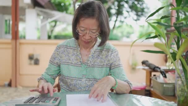 Старшая Азиатка Рассчитывает Баланс Домашней Террасе — стоковое видео