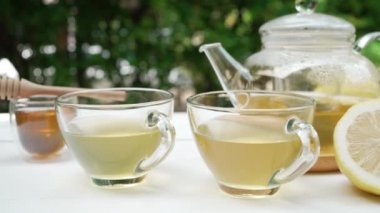 Kahve masasında servis edilen limonlu ve ballı sıcak yeşil çay.