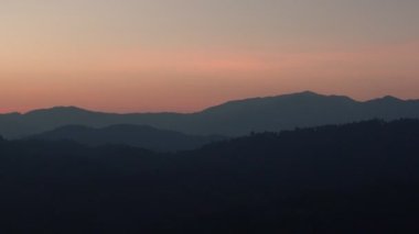 Güzel gün doğumunun ve dağların üzerindeki pembe gökyüzünün manzarası.