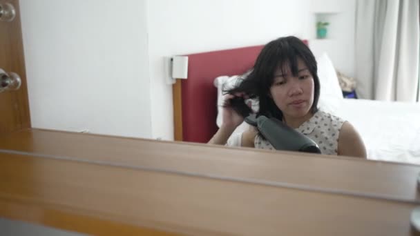 在卧室里用吹风机吹干头发的年轻亚洲女人的镜子视图 — 图库视频影像