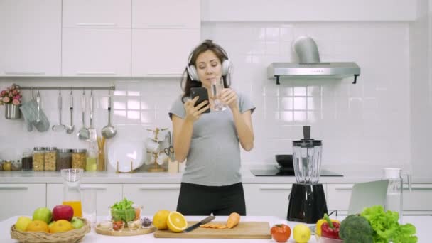 Biała Kobieta Ciąży Słuchać Muzyki Podczas Przygotowywania Zdrowego Śniadania Kuchni — Wideo stockowe