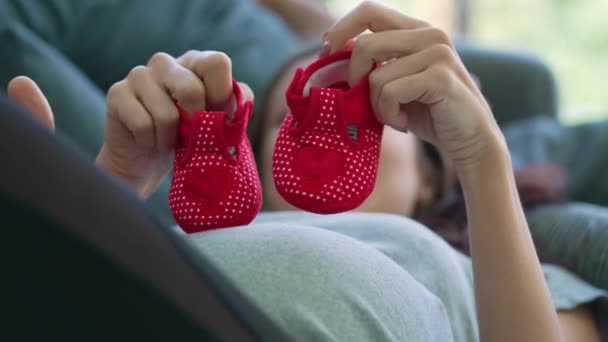 Biała Kobieta Ciąży Używa Małych Czerwonych Butów Chodzenia Brzuchu Leżąc — Wideo stockowe