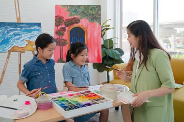 Genç Öğretmen Sanat sınıfında İki Kıza Resim Öğretmek