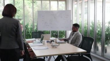 senior caucasian executive greeting with coworkers in meeting