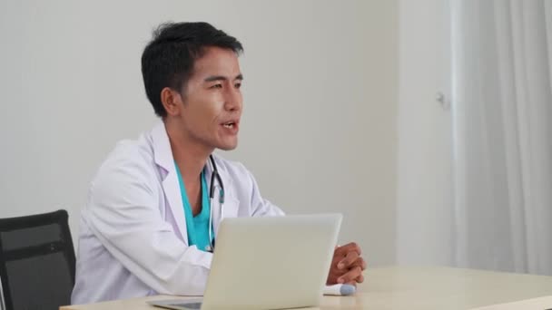 病院の外来で患者さんと話すアジアの医師 — ストック動画