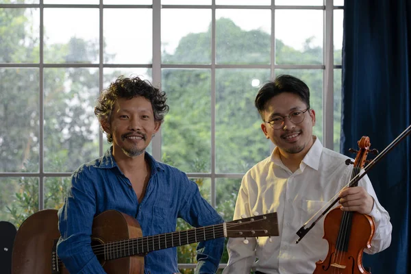 Retrato Dois Músicos Asiáticos Sorridentes Segurando Guitarra Violino — Fotografia de Stock
