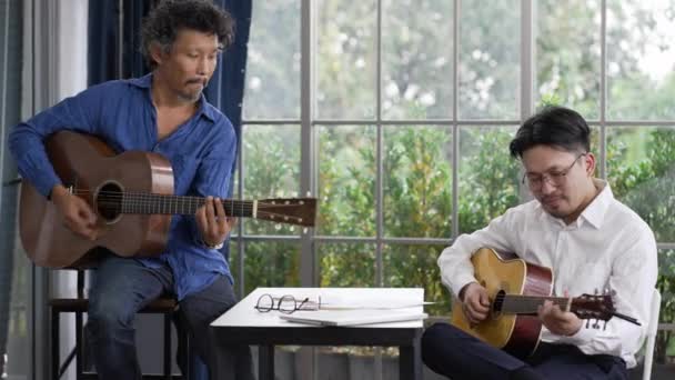 Två Asiatiska Musiker Spelar Gitarr Och Komponerar Sång — Stockvideo