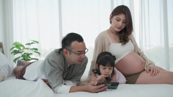 Asiatisk Familie Herunder Far Gravid Mor Datter Ved Hjælp Smartphone – Stock-video