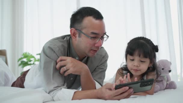Zoom Padre Asiático Hija Viendo Dibujos Animados Desde Teléfono Inteligente — Vídeo de stock