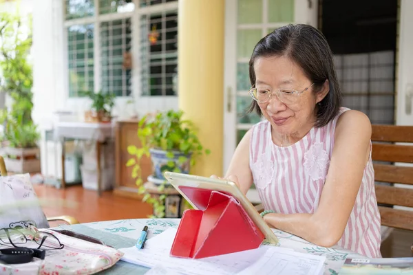 Sênior Asiático Mulher Usando Digital Tablet Para Trabalhar Partir Casa — Fotografia de Stock