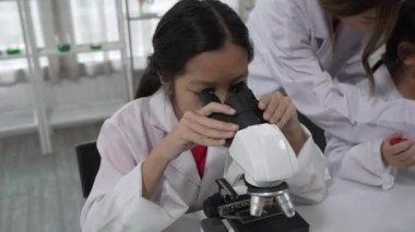 Bilim adamı, Genç Çocuklara Fen Laboratuvarında Mikroskop Kullanmayı Öğretiyor