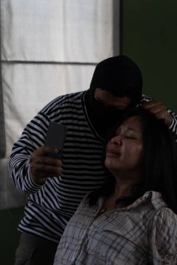 Genç Asyalı Kadın Adam Kaçırıyordu. Rehinenin Fotoğrafını Çekmek İçin Akıllı Telefon Kullanıyor.