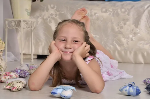 küçük kız gülümseyerek ve yerde yatarken