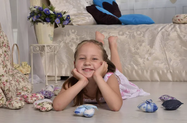 küçük kız gülümseyerek ve yerde yatarken