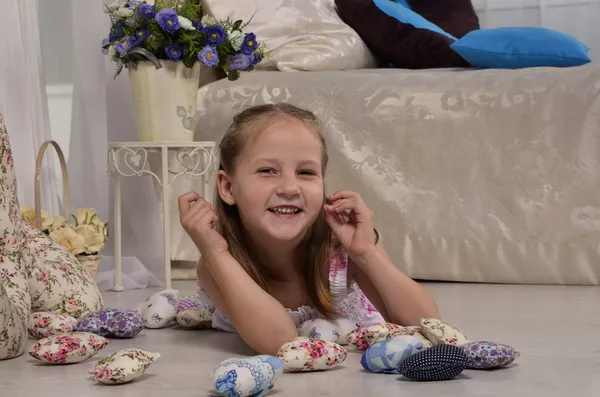 küçük kız gülümseyerek ve yerde yatarken