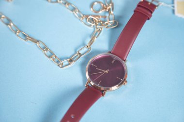 Mavi arka planda saati olan altın kolye