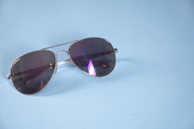 Mavi arka planda kadın güneş gözlüğü.