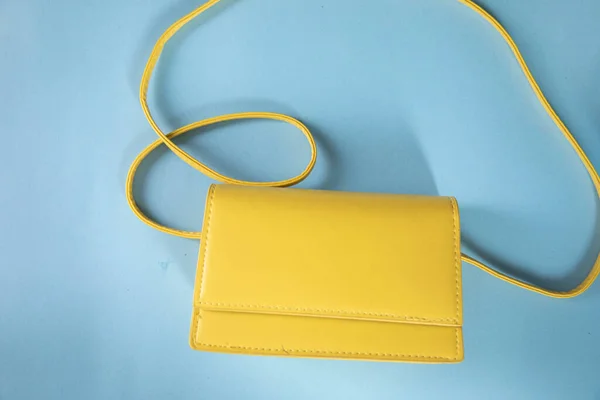 青いテーブルの上に黄色のハンドバッグ — ストック写真