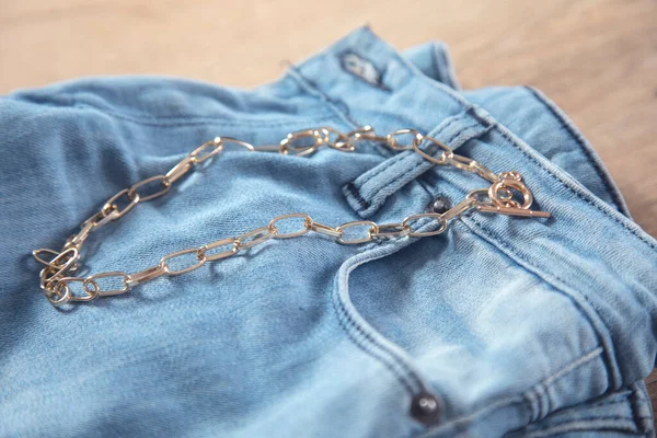Collana Dorata Sui Jeans Sul Tavolo — Foto Stock