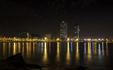 View of the promenade of Barcelona by night from the sea clipart