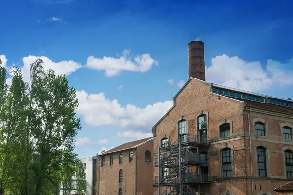 Industrieel gebouw met een toren en bomen — Stockfoto