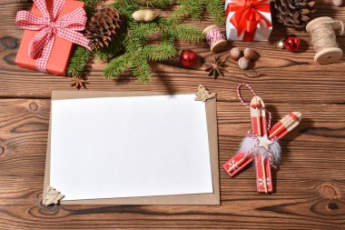 Bir zarf ve boş bir kağıt. Noel süslemeleri olan ahşap bir tole. - Mutlu yıllar. Uzayı kopyala Düz yatış, üst görünüm.