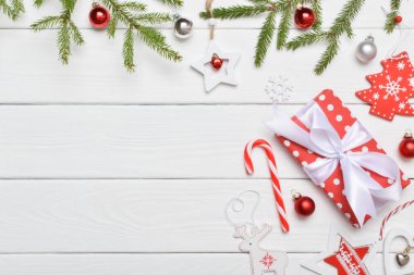 Bir hediye, baston şeker ve beyaz ahşap bir masada Noel oyuncakları ile şenlikli çerçeve arka planı. Kopyalayacak bir yer. Uzayı kopyala Düz yatış, üst görünüm.