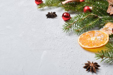 Noel arkaplanı şenliği. Köknar dalları ve konilerden, kurutulmuş portakallardan, elmalardan ve ahşap kar tanelerinden oluşan yeni yıl afişi. Düz konum, üst görünüm, kopyalama alanı