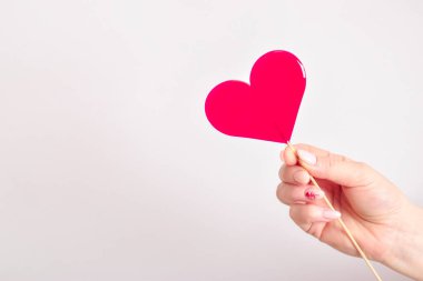 Bir kızın ellerinde kalp şeklinde bir lolipop. Sevgililer Günü. Boşluğu kopyala.
