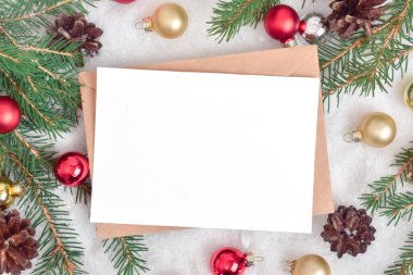 Kraft zarfının yeni yıl kompozisyonu ve karda kırmızı ve sarı çiçeklerin şenlikli dekoru. Noel için şenlik arka planı. Kopyalamak için yer var. Düz konum, üst görünüm.