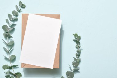 Mavi arka planda okaliptüslü bir zarf içeren bir mektubun taslağı. Romantik kartpostal. Mesaj için boş bir kart. Düz düzen, üst görünüm, kopyalanacak yer.