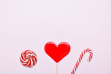 Sevgililer Günü için arka plan. Pembe arka planda üç lolipop. Uzayı kopyala Düz yatış, üst görünüm.