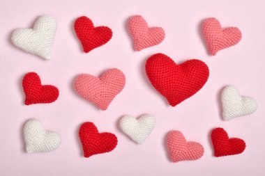 Bir dizi farklı renkte kalp pembe bir arka planda yatıyor. Sevgililer Günü için arka plan. Bir kartpostal, 14 Şubat için bir pankart, kopyalanacak bir yer..