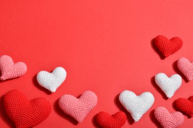 Kırmızı arka planda bir dizi farklı renkte kalp bulunur. Sevgililer Günü için arka plan. Bir kartpostal, 14 Şubat için bir pankart, kopyalanacak bir yer..