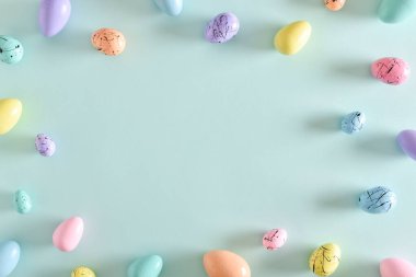 Paskalya kartpostalında yatak boyalı yumurtalar ve mekanın bir kopyası var. Boyalı yumurta çerçevesi. Uzayı kopyala Düz yatış, üst görünüm.